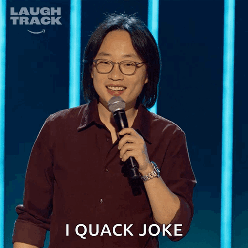 a man holding a microphone with the words i quack joke behind him