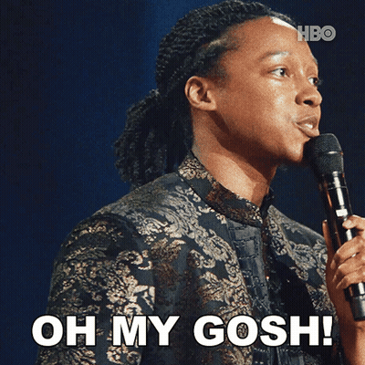 A Man Holding A Microphone With The Words Oh My Gosh Below Him GIF