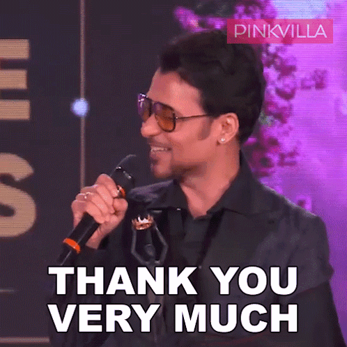 A Man Holding A Microphone With The Words Thank You Very Much In Front Of Him GIF