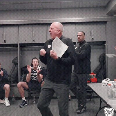 A Man Holding A Piece Of Paper In Front Of A Man Wearing A Bulls Jersey GIF