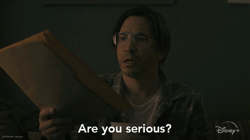 A Man Holding A Piece Of Paper With The Words Are You Serious Behind Him GIF