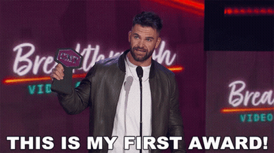 A Man Holding A Plaque That Says " This Is My First Award " On It GIF