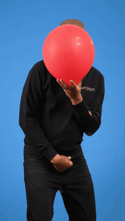 A Man Holding A Red Balloon In Front Of His Face Wearing A Black Sweatshirt With The Word Jesus On The Sleeve GIF