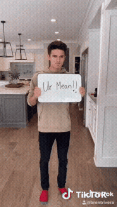 A Man Holding A Sign That Says Ur Mean On It GIF