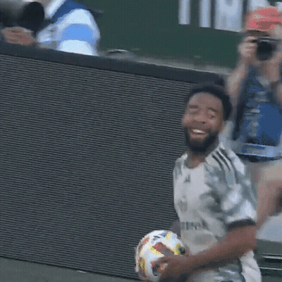 A Man Holding A Soccer Ball With A Shirt That Says Allmook On It GIF
