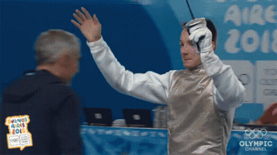 A Man Holding A Sword In Front Of An Olympic Channel Sign GIF