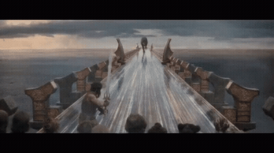 A Man Holding A Sword Is Walking Across A Bridge Over A Body Of Water GIF