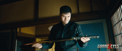 A Man Holding A Sword With Snake Eyes Written On The Bottom Right GIF