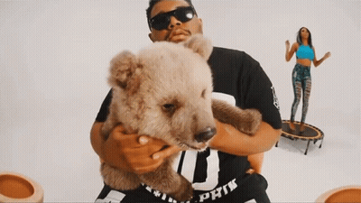 A Man Holding A Teddy Bear Wearing A Shirt That Says Pink GIF