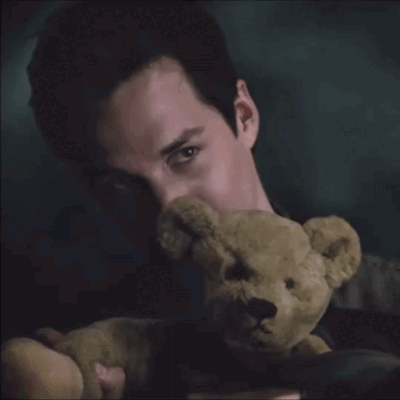 A Man Holding A Teddy Bear With His Face Covered GIF