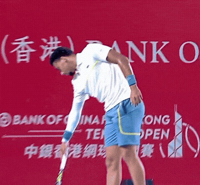 A Man Holding A Tennis Racket In Front Of A Bank Of China Sign GIF