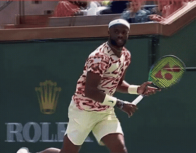 A Man Holding A Tennis Racket In Front Of A Bnp Sign GIF