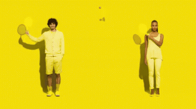 A Man Holding A Tennis Racquet And A Woman Holding A Tennis Racket On A Yellow Background GIF