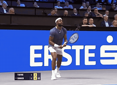 A Man Holding A Tennis Racquet In Front Of A Sign That Says Erste 'S GIF
