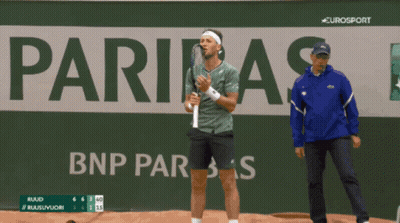 A Man Holding A Tennis Racquet In Front Of A Sign That Says Eurosport GIF