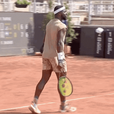 A Man Holding A Tennis Racquet On A Court GIF