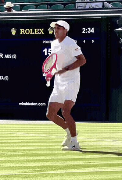 A Man Holding A Tennis Racquet On A Court With A Rolex Sign In The Background GIF