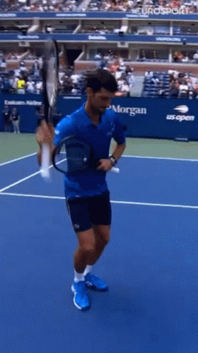 A Man Holding A Tennis Racquet On A Tennis Court With Morgan On The Side GIF