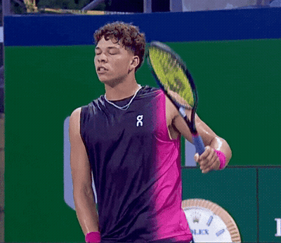 A Man Holding A Tennis Racquet While Wearing A Tank Top That Says Oc GIF