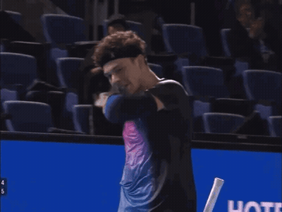A Man Holding A Tennis Racquet With The Number 4 On The Handle GIF