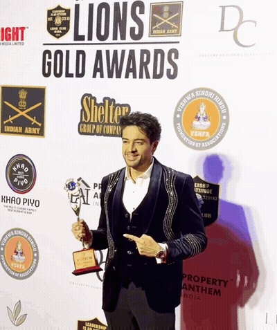 A Man Holding A Trophy At The Lions Gold Awards GIF