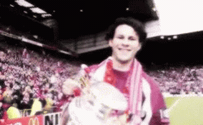 A Man Holding A Trophy In Front Of A Mcdonald 'S Banner GIF