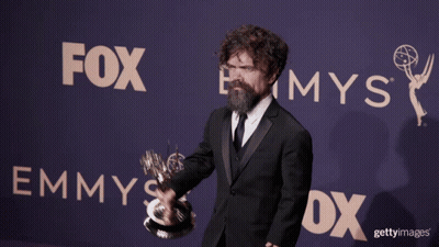 A Man Holding A Trophy In Front Of A Sign That Says Fox GIF