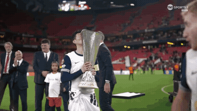 A Man Holding A Trophy On A Soccer Field With Tnt Sports On The Bottom Right GIF