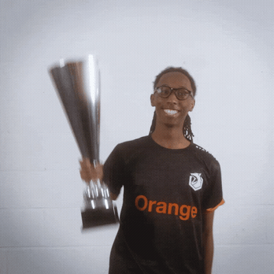 A Man Holding A Trophy Wearing An Orange Shirt GIF