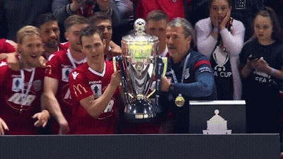 A Man Holding A Trophy With A Mcdonald 'S Logo On It GIF
