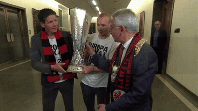 A Man Holding A Trophy With Europa On His Shirt GIF