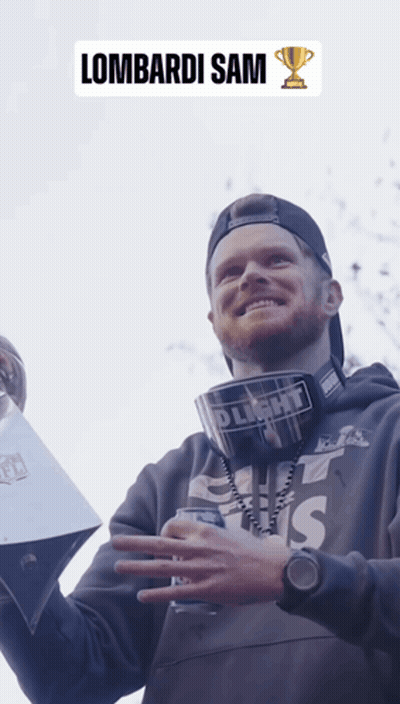 A Man Holding A Trophy With The Name Lombardi Sam On The Bottom GIF