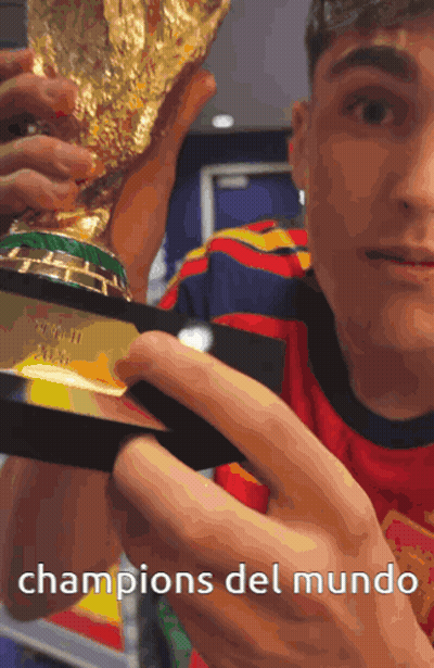 A Man Holding A Trophy With The Words Champions Del Mundo Below Him GIF