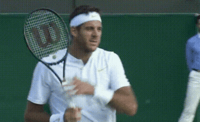 A Man Holding A Wilson Tennis Racquet On A Green Court GIF