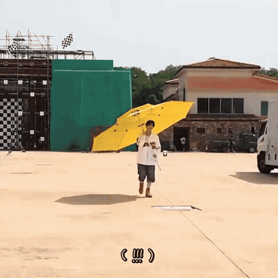 A Man Holding A Yellow Umbrella With The Word Angels On The Front GIF