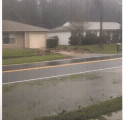 A Man Holding An American Flag Runs Down The Street GIF