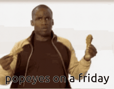 A Man Holding Up A Chicken Wing With The Words Popeyes On A Friday Written Below Him GIF