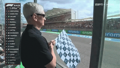 A Man Holds A Checkered Flag In Front Of A Screen That Says Espn On It GIF