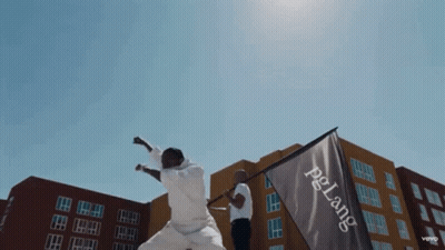 A Man Holds A Flag That Says Pelang On It GIF