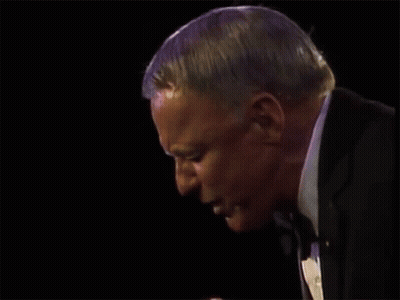 A Man Holds A Microphone And Says Anywhere GIF
