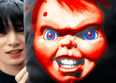 A Man Holds A Pillow With A Picture Of Chucky On It In Front Of His Face GIF