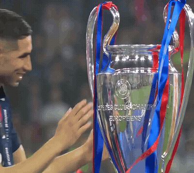 A Man Holds A Trophy That Says ' Uefa Champions League Europeans ' On It GIF
