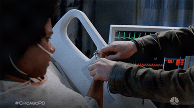 A Man Holds A Woman 'S Hand In Front Of A Monitor That Says Nbc GIF