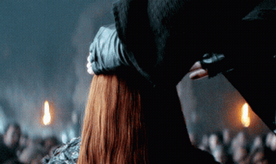 A Man Holds A Woman 'S Head In A Dark Room GIF