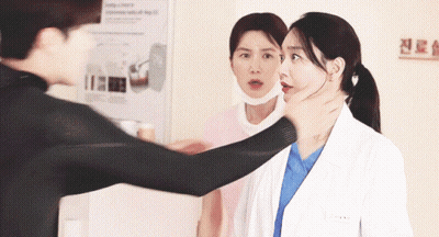 A Man Holds A Woman 'S Neck While A Nurse Looks On GIF