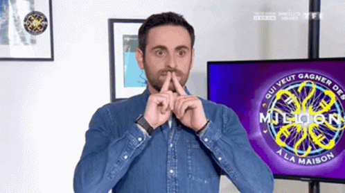 A Man Holds His Finger To His Mouth In Front Of A Tv Screen That Says Million A La Maison GIF