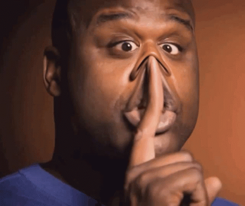 A Man Holds His Finger To His Mouth While Making A Funny Face GIF