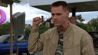 A Man Holds His Fist Up In Front Of A Sign That Says 113 Cents GIF
