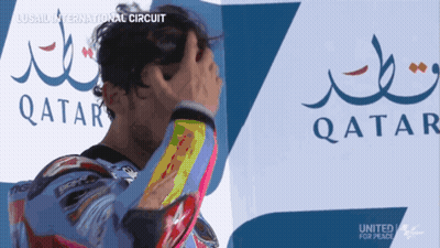 A Man Holds His Head In Front Of A Qatar Logo GIF