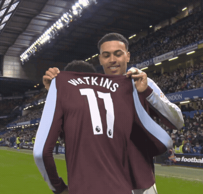 A Man Holds Up A Jersey That Says Watkins 11 GIF